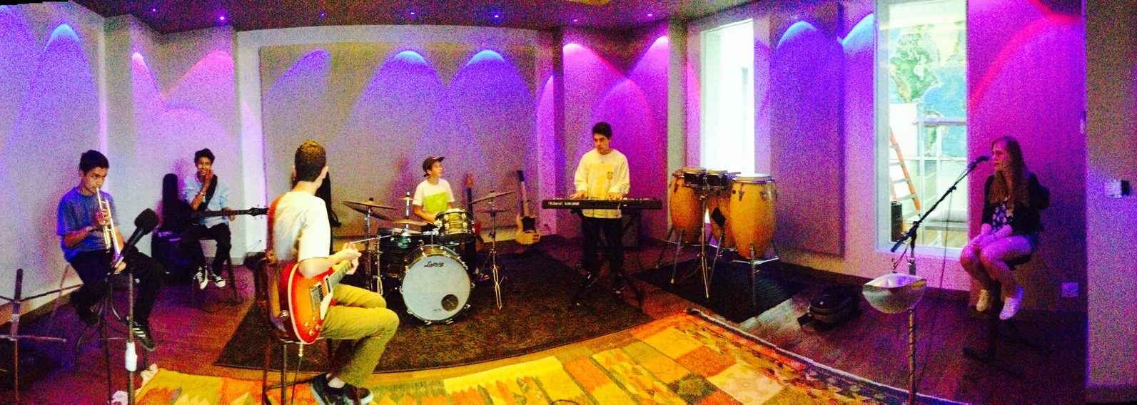 Young band rehearsing together in a professional live room during an artist development session