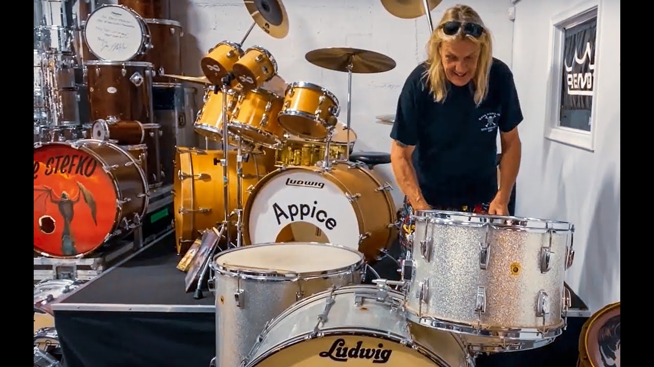 Nicko McBrain at the Modern Drummer Hall of Fame museum with Carmine Appice's Ludwig kit and Joe Stefko's Bat Out of Hell kit from the David Frangioni collection